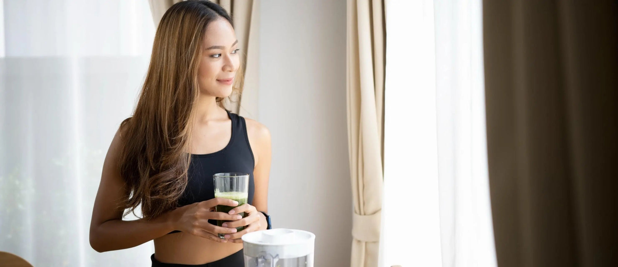 A woman drinking a smoothie wondering about the signs of the heavy metal detox working